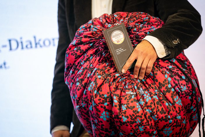 Kochtasche im Arm des Gewinners des Deutschen Award für Nachhaltigkeitsprojekte