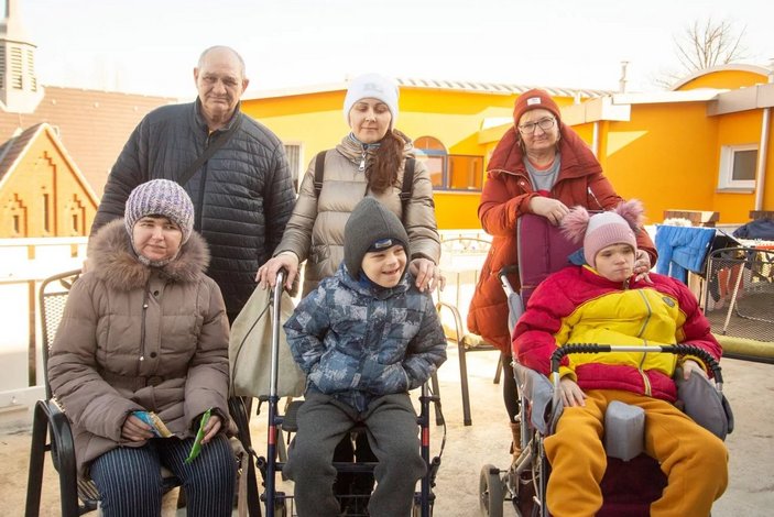 Zwei Kinder in Rollstühlen und ihre Betreuer:innen