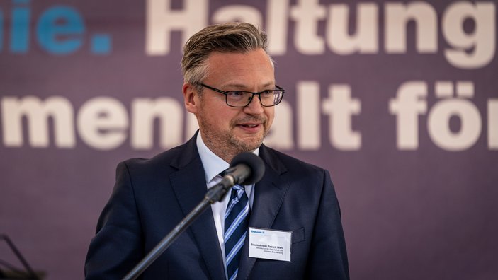 Staatssekretär Patrick Wahl bei seiner Rede auf dem Podium.