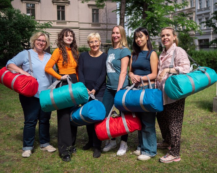 Die Mitarbeitenden präsentieren volle Taschen mit Babygeschenken.
