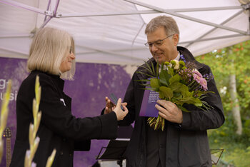 Ulrike Menzel, Vorsitzende des Diakonischen Rates des DWB, überreicht Rektor Markus Müller die Wichern-Plakette. 